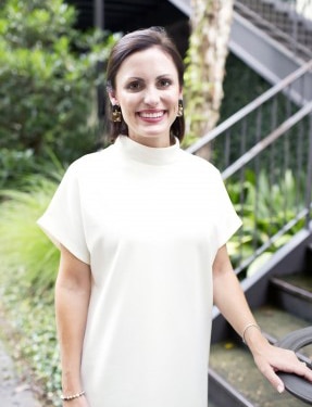 A Woman Standing In Front Of A Fence